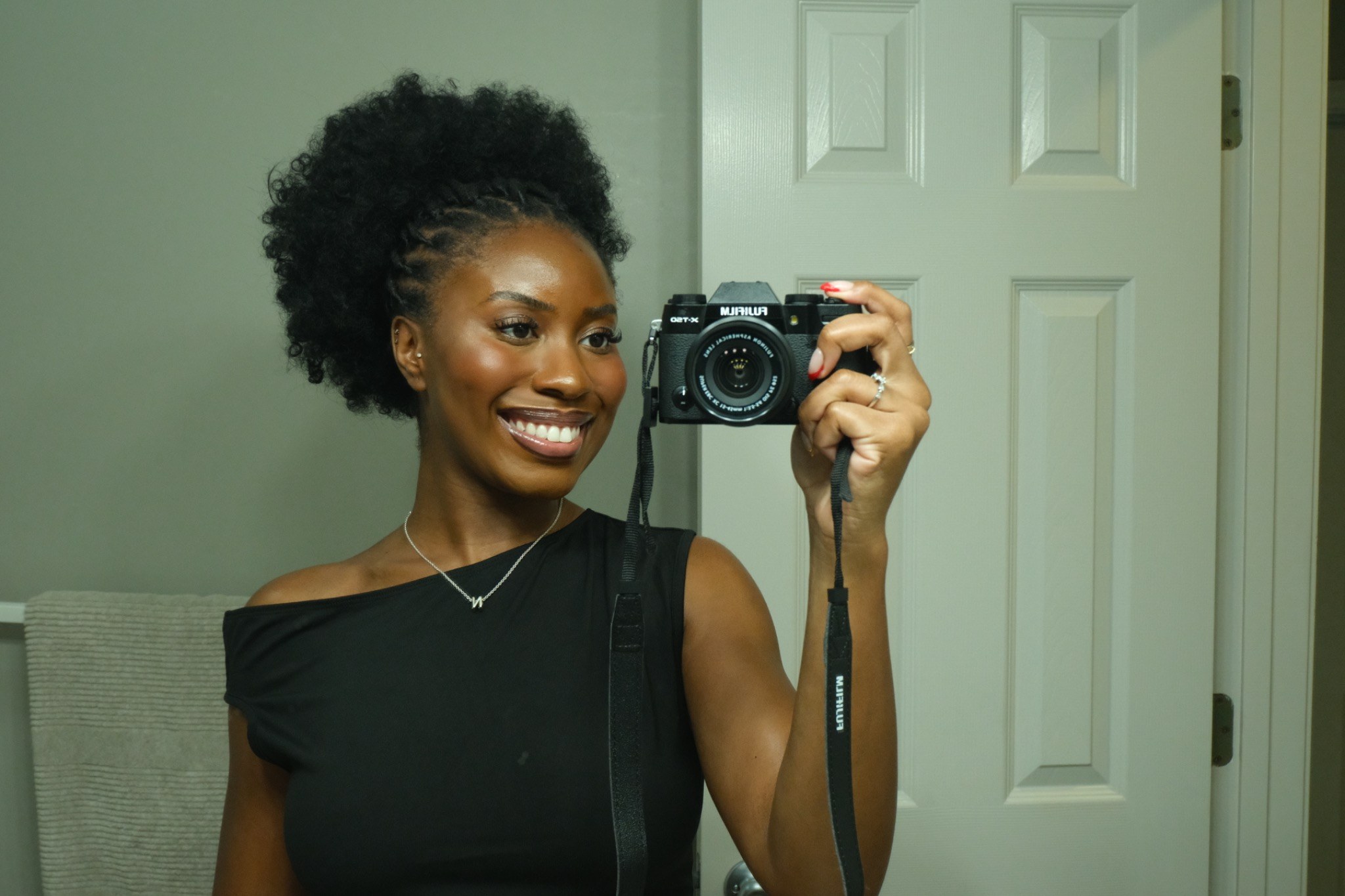Temisan smiling while holding her Fujifilm camera