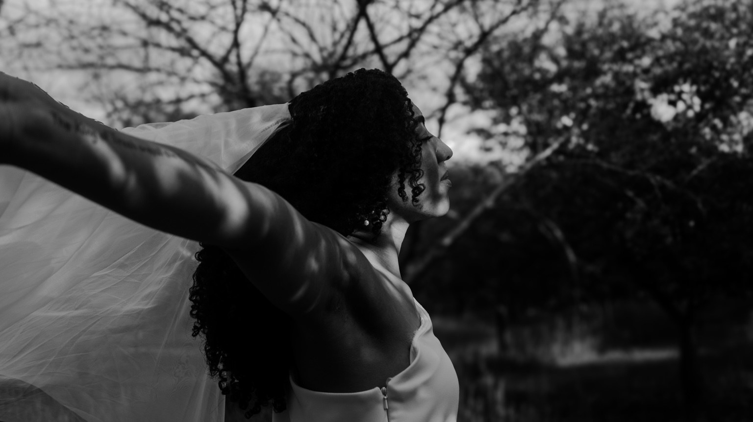Black and white bridal portrait with veil in motion